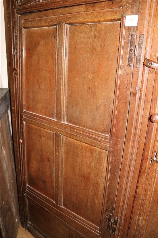 A 17th century oak carved and panelled two door hanging cupboard, W.150cm (a.f.)